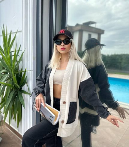 Denim ve krem renk detaylı cepli oversize hırka giyen bir kadın, modern ve rahat bir tarz sergiliyor.