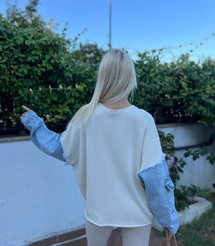 Denim detaylı triko kazak giyen, bordo tayt ve kürklü çizmelerle kombin yapan bir kadın. Kazak ekru rengiyle sade ve şık bir görünüm sunuyor.