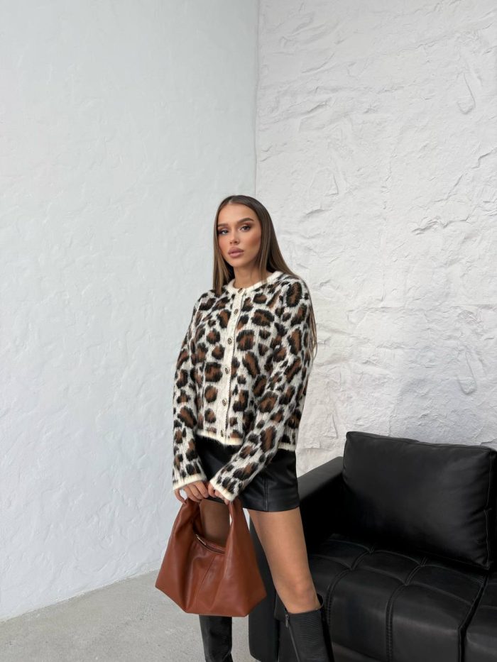 leopar-desenli-dugmeli-hirka-6 Leopar desenli düğmeli hırka giyen bir kadın. Hırka siyah deri etek, kahverengi bir çanta ve siyah çizmelerle kombinlenmiş.