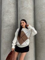 Ella Style gri baklava desenli oversize triko kazak giyen bir kadın. Kazağı siyah mini etek ve gümüş detaylı bir çantayla kombinlemiş.