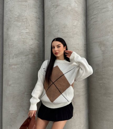 Ella Style gri baklava desenli oversize triko kazak giyen bir kadın. Kazağı siyah mini etek ve gümüş detaylı bir çantayla kombinlemiş.