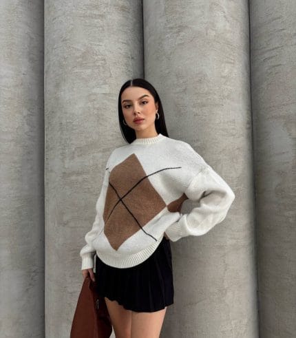 Ella Style gri baklava desenli oversize triko kazak giyen bir kadın. Kazağı siyah mini etek ve gümüş detaylı bir çantayla kombinlemiş.