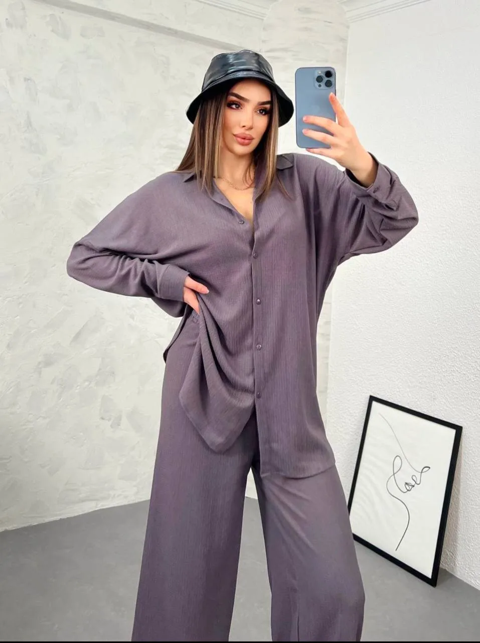 Modern tasarıma sahip oversize ikili takım ile günlük şıklık yakalayan kadın. Rahat kesim gömlek ve bol paça pantolon kombini.